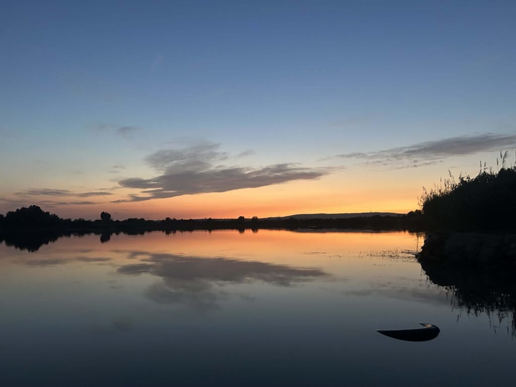 Naplemente a nyugodt vízparton